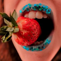 Close-up of woman holding strawberry