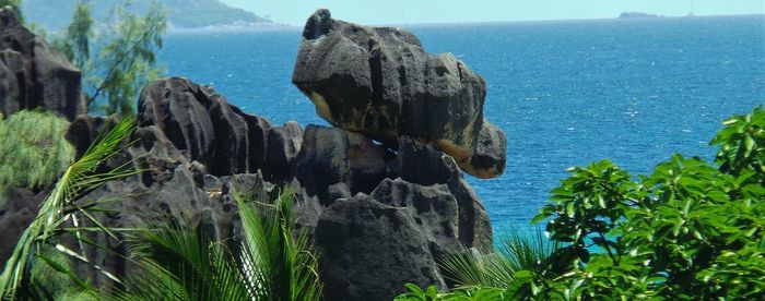 Panoramic view of rocks and sea against sky