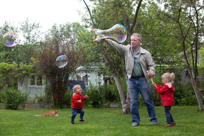 Full length of father with daughter against trees