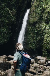 Woman standing by waterfall in forest