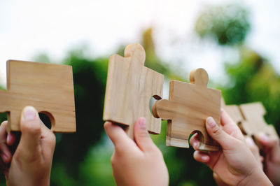 Cropped hands of woman holding toy blocks against white background
