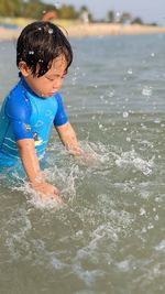 Boy splashing water in sea