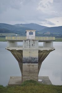 Built structure by lake against sky