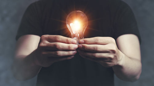 Close-up of hand holding light bulb