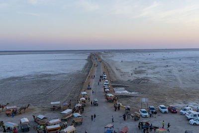 High angle view of people on beach against sky during sunset
