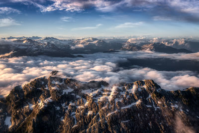 Aerial view of snowcapped mountains against sky during sunset