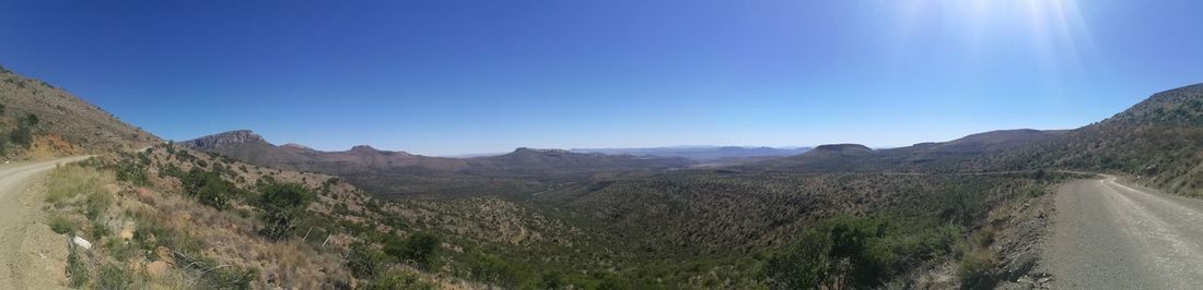 Panoramic view of mountains against clear blue sky