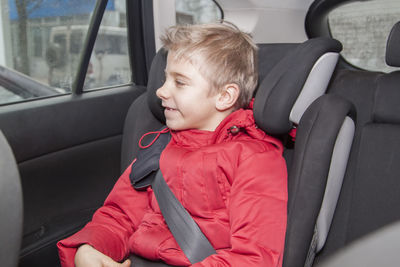 View of boy sitting in car