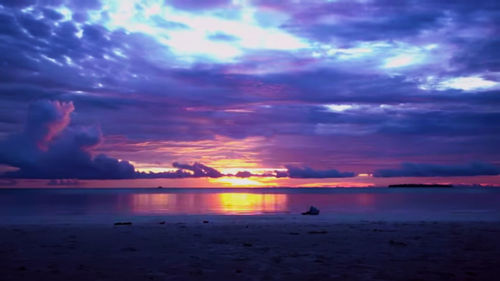 Scenic view of sea against dramatic sky during sunset