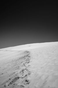 Scenic view of desert against clear sky during winter