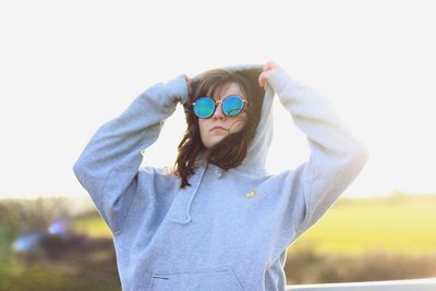 Portrait of man wearing sunglasses standing against sky