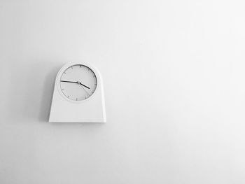 Close-up of clock against white wall