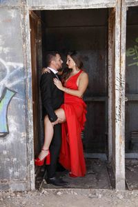 Rear view of couple standing by red wall