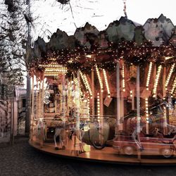 Illuminated carousel against sky at night