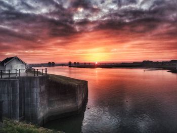 Scenic view of sea against dramatic sky during sunset