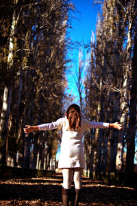 Full length rear view of woman standing by tree