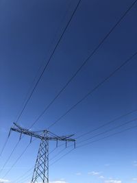 Low angle view of power lines against blue sky