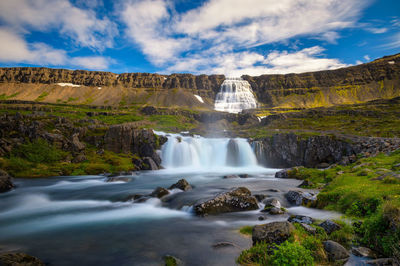 Scenic view of waterfall against sky