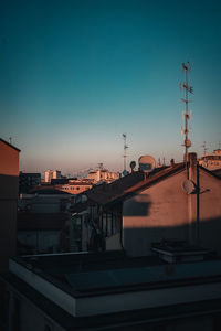 Buildings in city against clear sky during sunset
