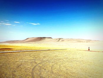 Scenic view of desert against blue sky