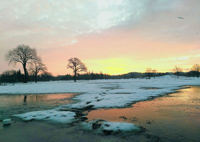Scenic view of frozen lake against sky during sunset