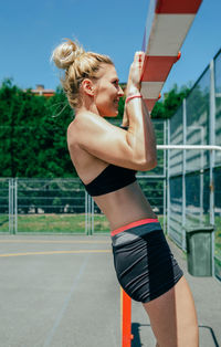 Midsection of woman with arms raised standing outdoors