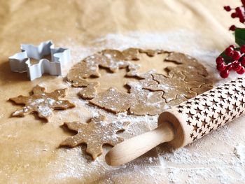 Dough with pastry cutter and rolling pin on table