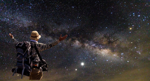 Full length rear view of man standing at night