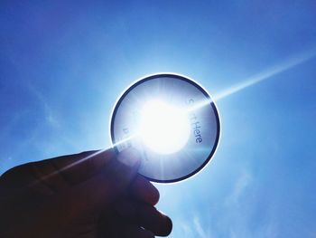 Low angle view of person hand against blue sky