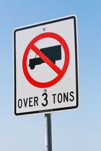 Low angle view of road sign against sky