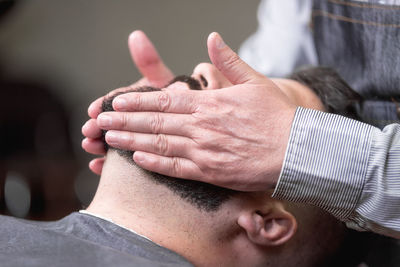 Midsection of barber giving massage to customer in salon