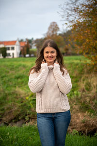 Portrait of a smiling young woman standing in autumn