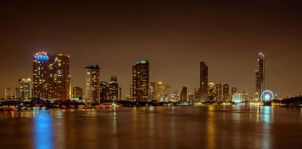 Illuminated buildings against sky at night