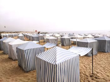 Chairs on beach against clear sky