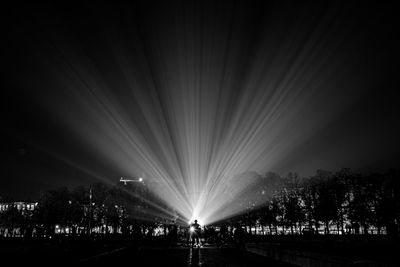 Crowd at illuminated city against sky at night