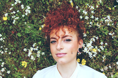 Portrait of young woman with pierced on face against plants