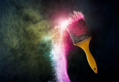 Digital composite image of paintbrush with powder paint against cloudy sky