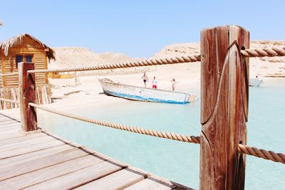 Wooden pier against clear blue sky