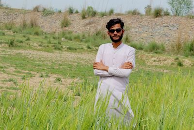 Portrait of young man standing on field