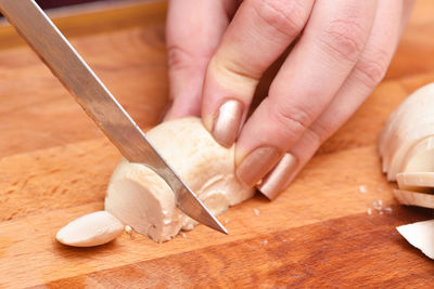 Close-up of hand holding ice cream on cutting board