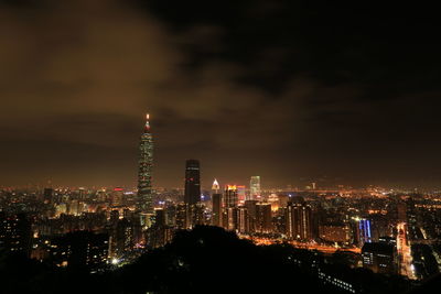 Illuminated cityscape against sky at night