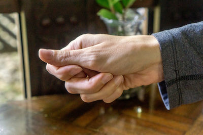 Close-up of hands against table