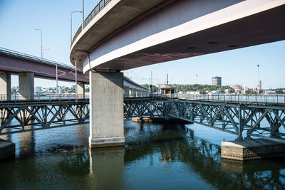 Bridge over river in city against sky