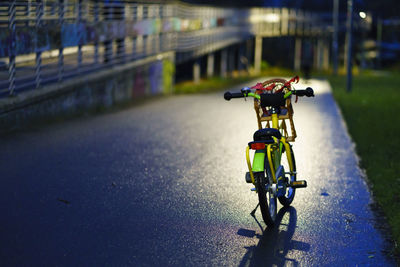 Bicycle parked on road at night