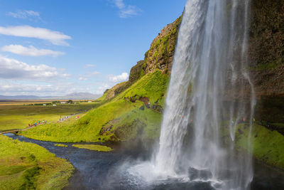 Scenic view of waterfall against sky