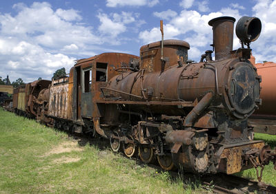 Abandoned train on railroad track against sky