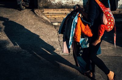 Low section of people walking on footpath in city