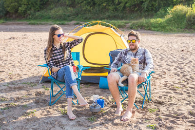 Rear view of couple sitting on land