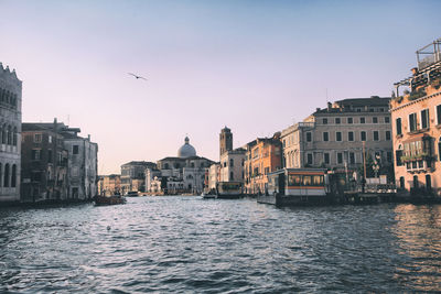 View of canal and buildings against sky