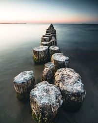 High angle view of wooden posts in sea against sky